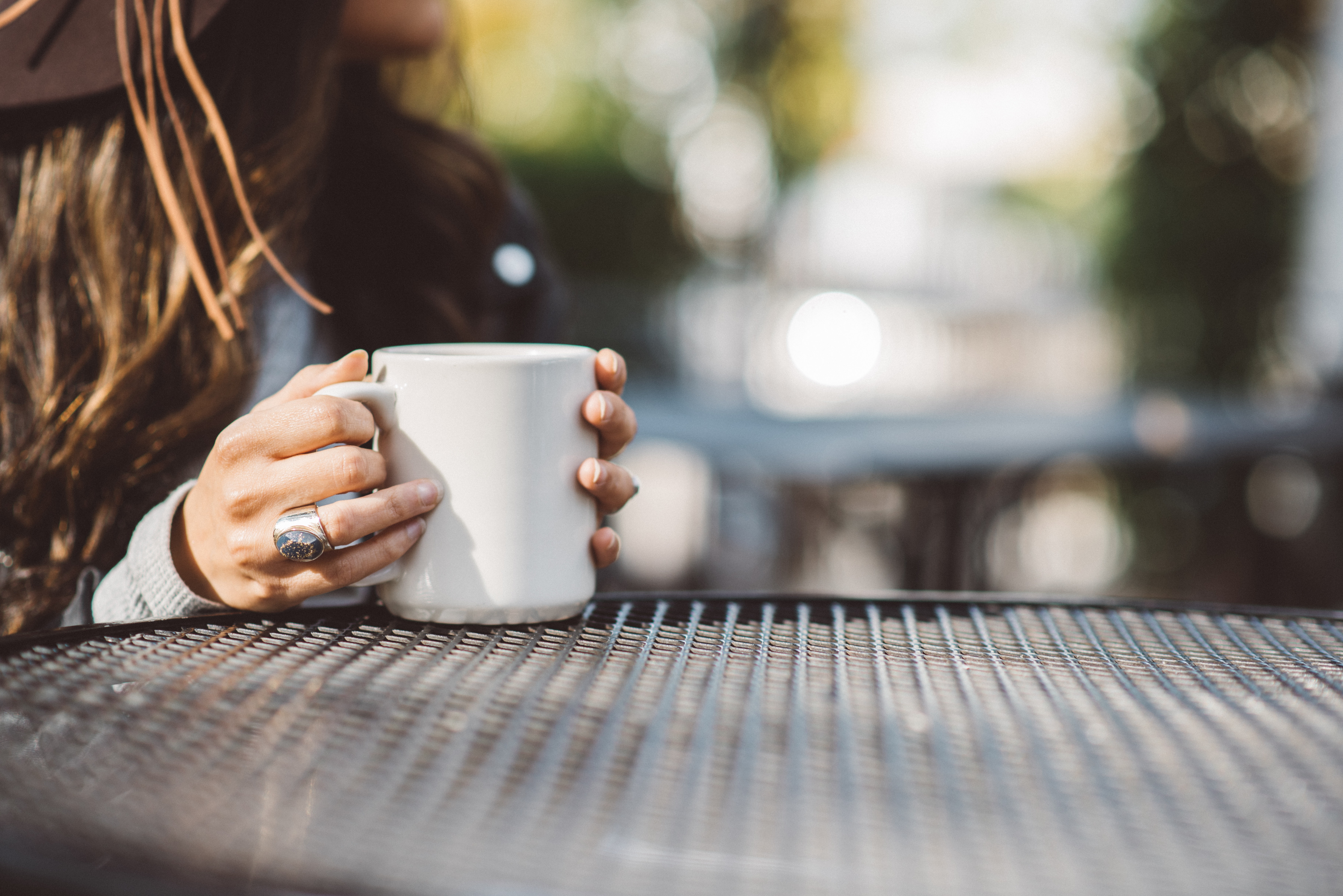 a girl holding a cup of coffee and doing a positive