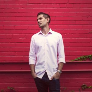 Male job seeker standing in front of a red wall