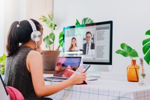 a woman sitting in front of a computer editing a video resume