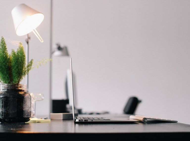 A clean and tidy work space with lamp and laptop to conquer job boredom