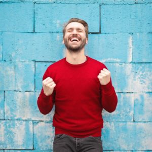 A happy adult wearing red sweatshirt and follow what successful people do