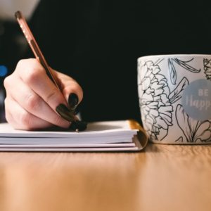 A woman holding a pen while creating a resume in the best writing places