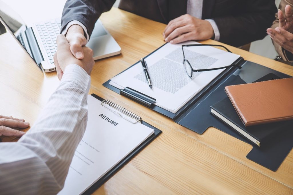 hiring manager handshakes job applicant after interview