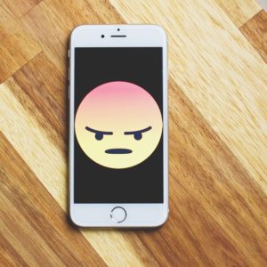 angry emoticon in a smartphone because of ripoff reviews