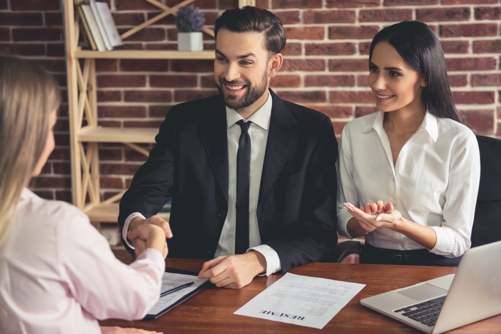 two hiring managers smiling at the job applicant