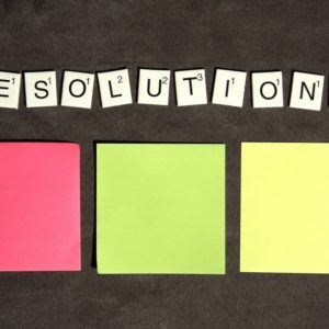 Three sticky notes and scrabble tiles to show listing of career resolutions