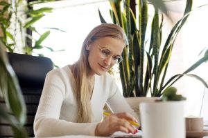 a woman sitting on her working desk and happy with her career