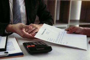 An employee holding resignation letter submitting to supervisor