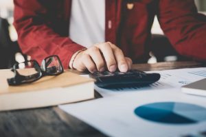 Man computing his salary requirements while writing a resume