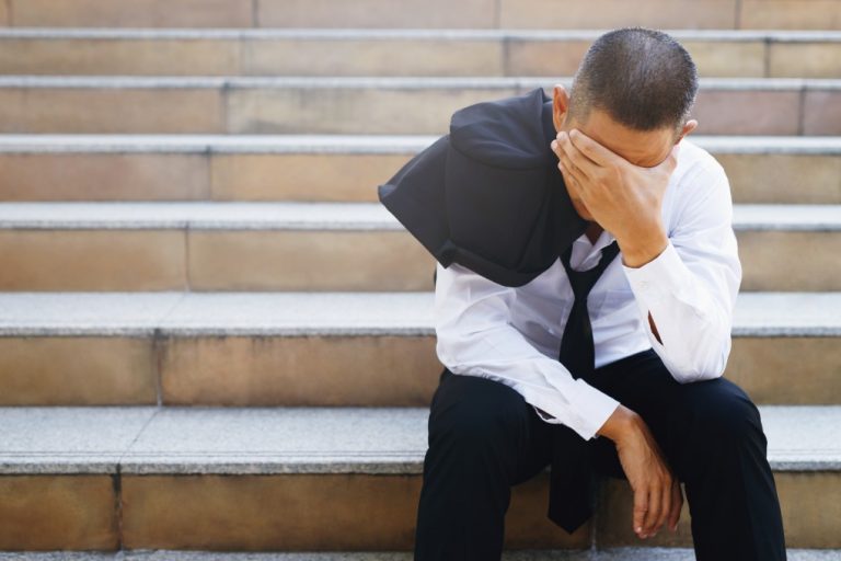 a man in suit feeling depressed due to job loss