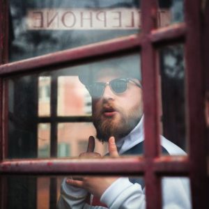 A man follows up after his interview inside a telephone booth