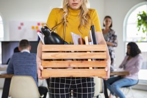 woman carrying a wooden box after being laidoff