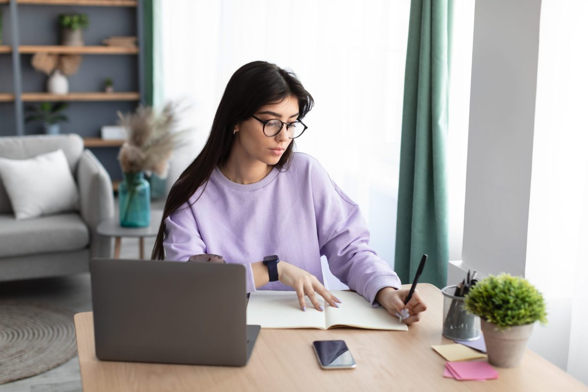 A woman writing extracurricular activities on resume