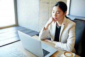 One of the professional resume writers assessing a client's resume on her laptop