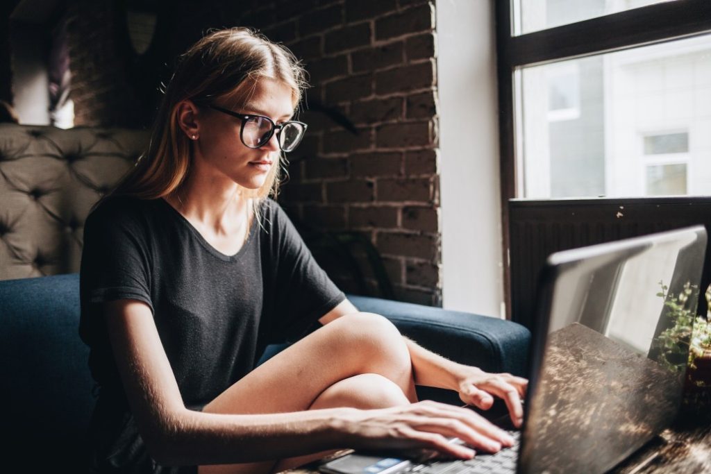 woman writing education and work experience on resume