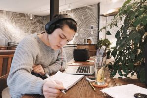 Young man in a cafe researching where to put education section in his resume